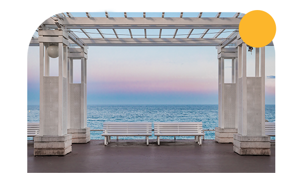 Deux bancs blancs sur la Promenade des Anglais face à la mer