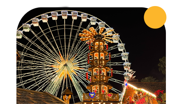 Grande roue de nuit avec la tour du marché de Noël de Nice