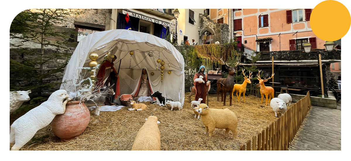 Nativity scene in one of the streets of Lucéram, featuring Mary, Joseph and the baby Jesus, with animals gathered all around.