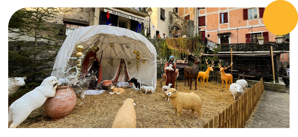 Il s'agit d'une crèche dans une rue du village de Lucéram, en grandeur nature avec des moutons, des cerfs, des agneaux et de la paille au sol. Dans la crèche il y a Joseph, Marie et le bébé jésus.